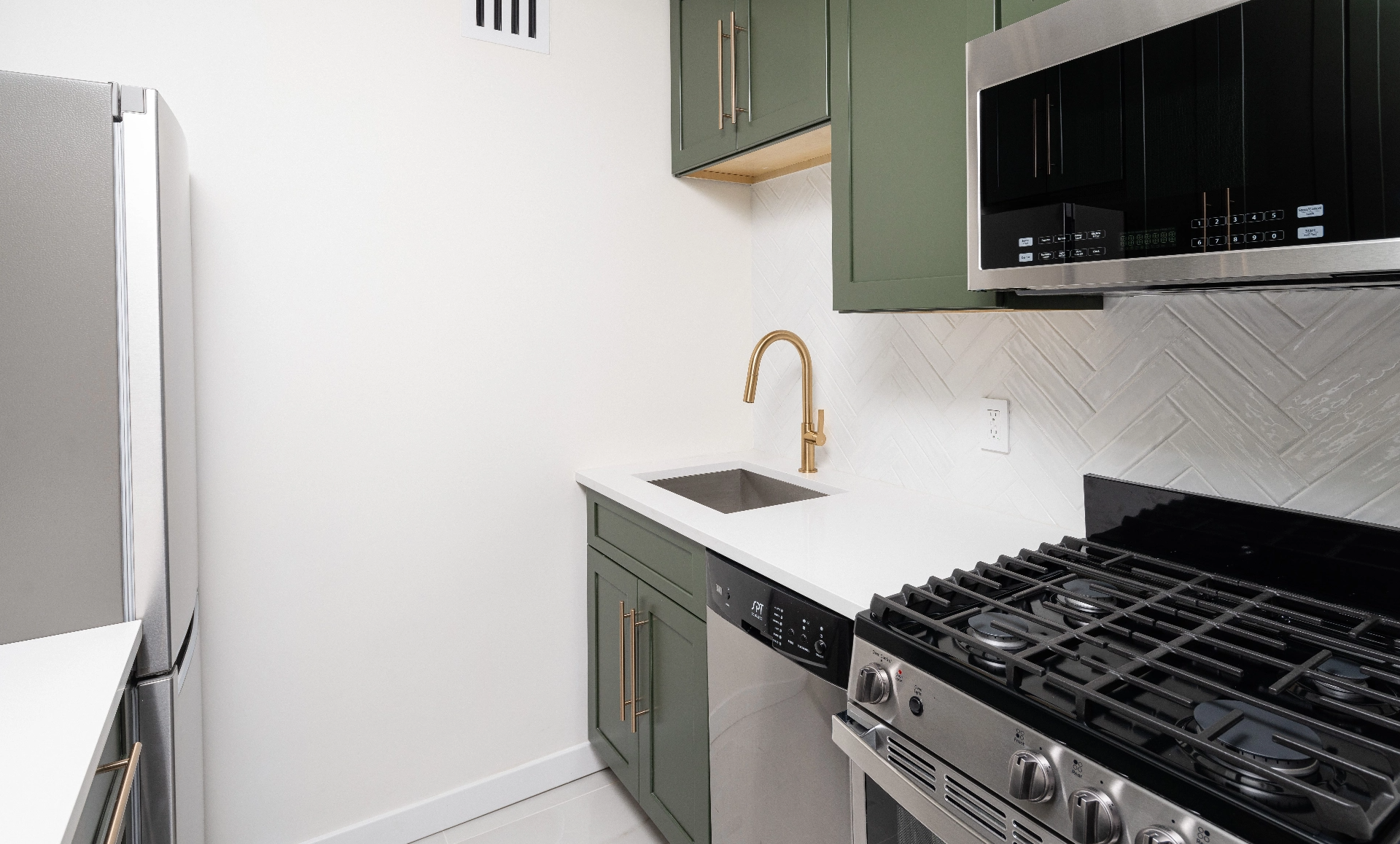 After renovation view of Manhattan studio apartment showing modern kitchen and living space transformation