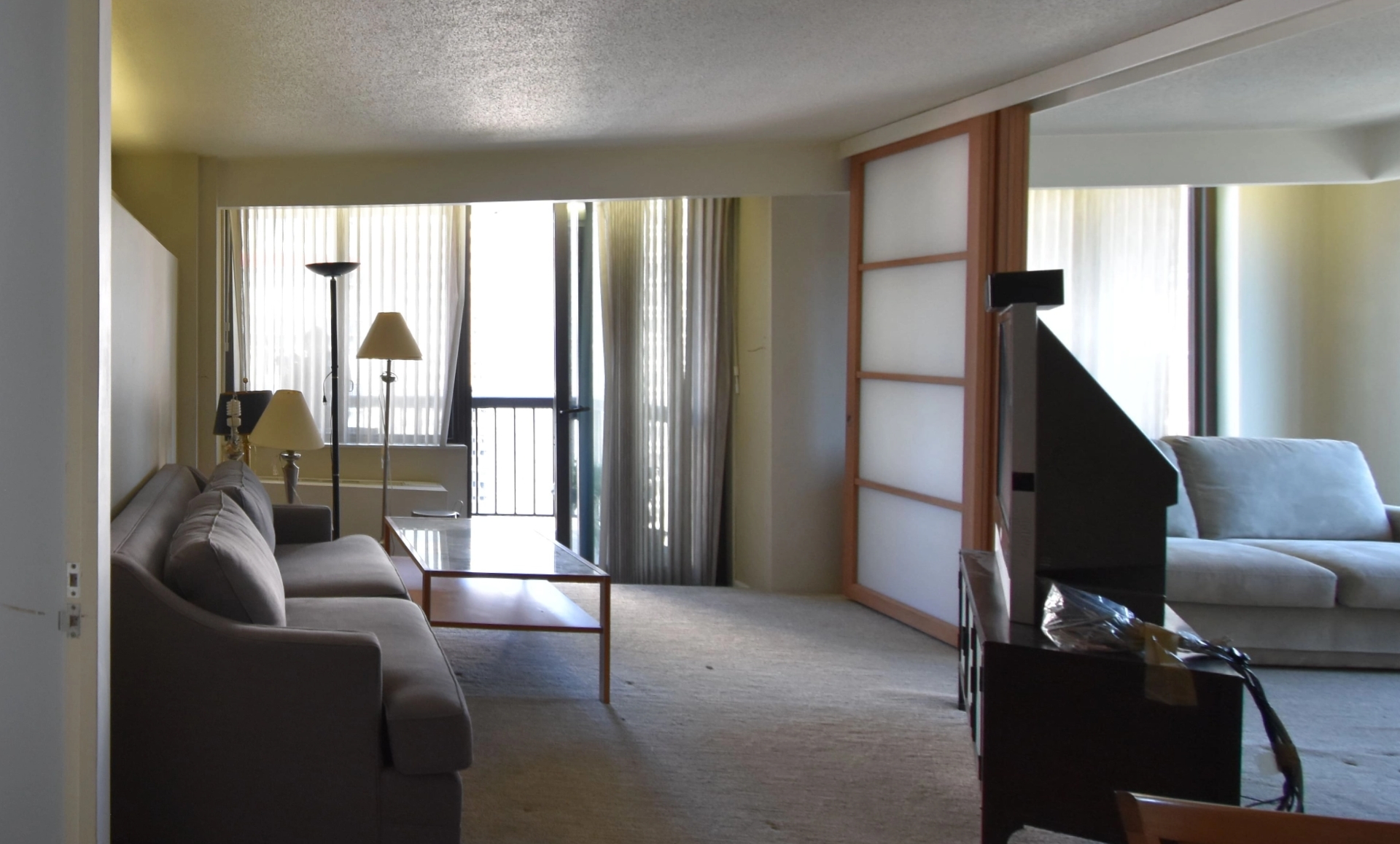 Manhattan condo living space before renovation showing outdated design