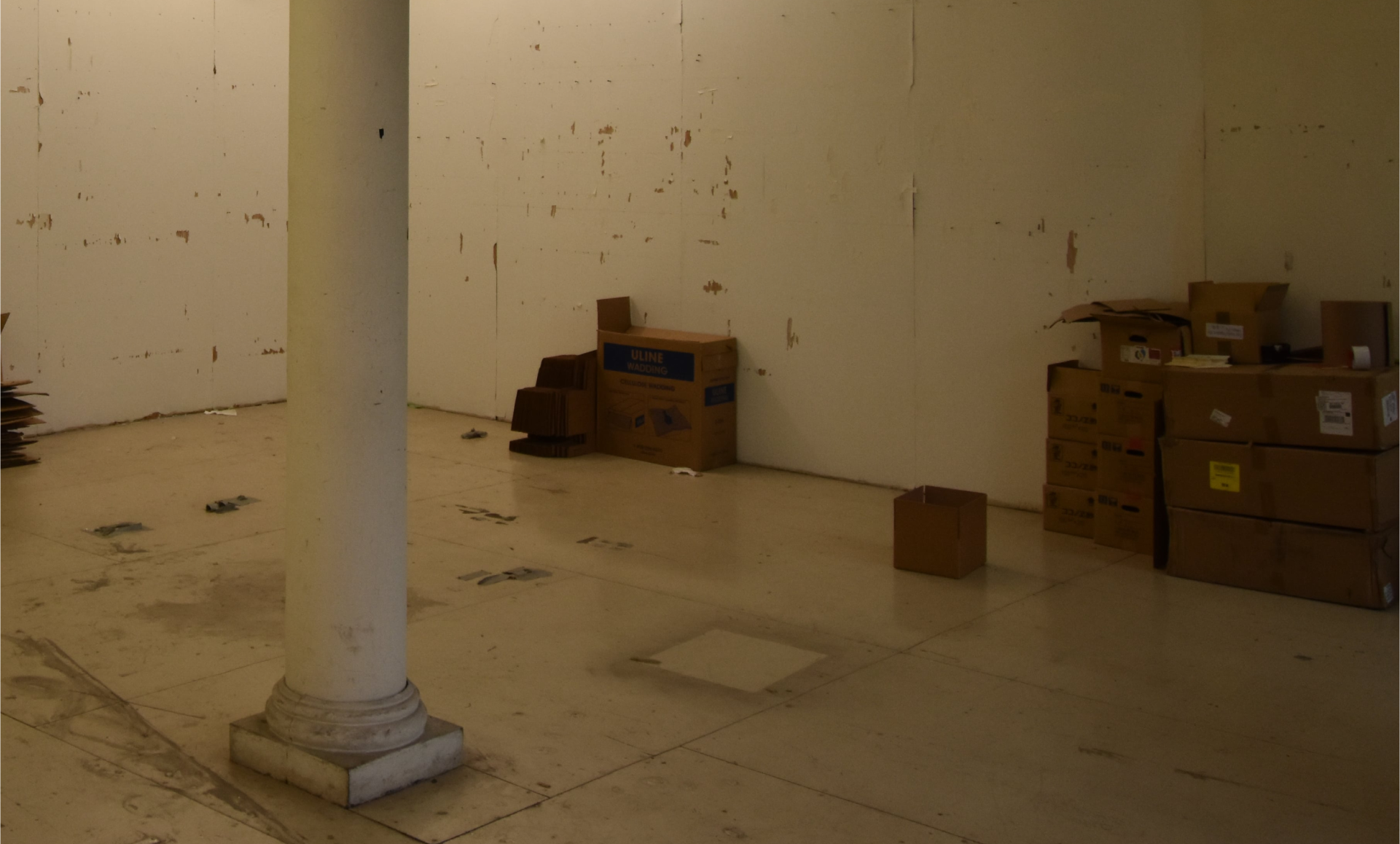 SoHo office renovation before photo showing warehouse storage area with plywood surfaces