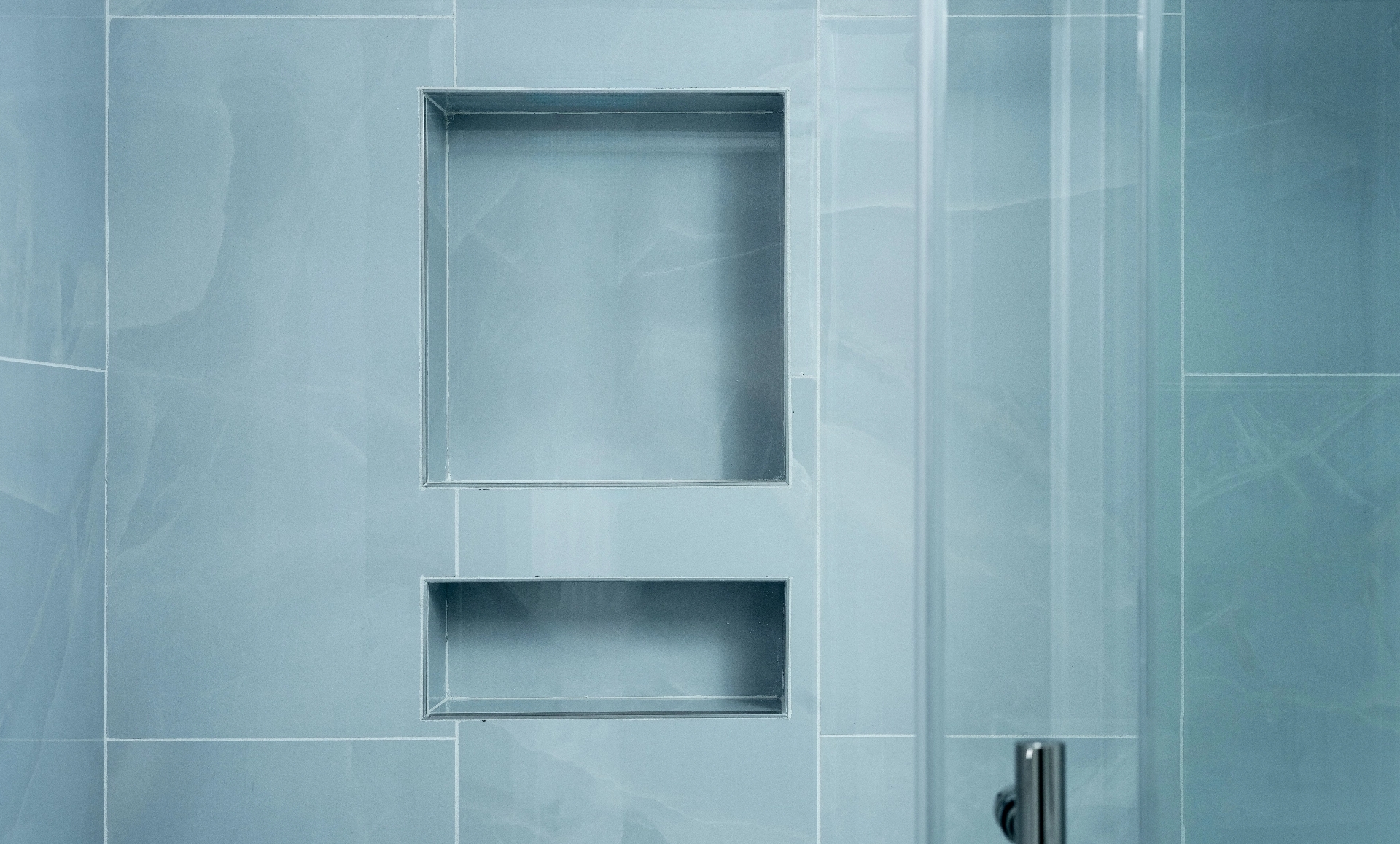 UES apartment with glass subway tile accent wall in guest bathroom