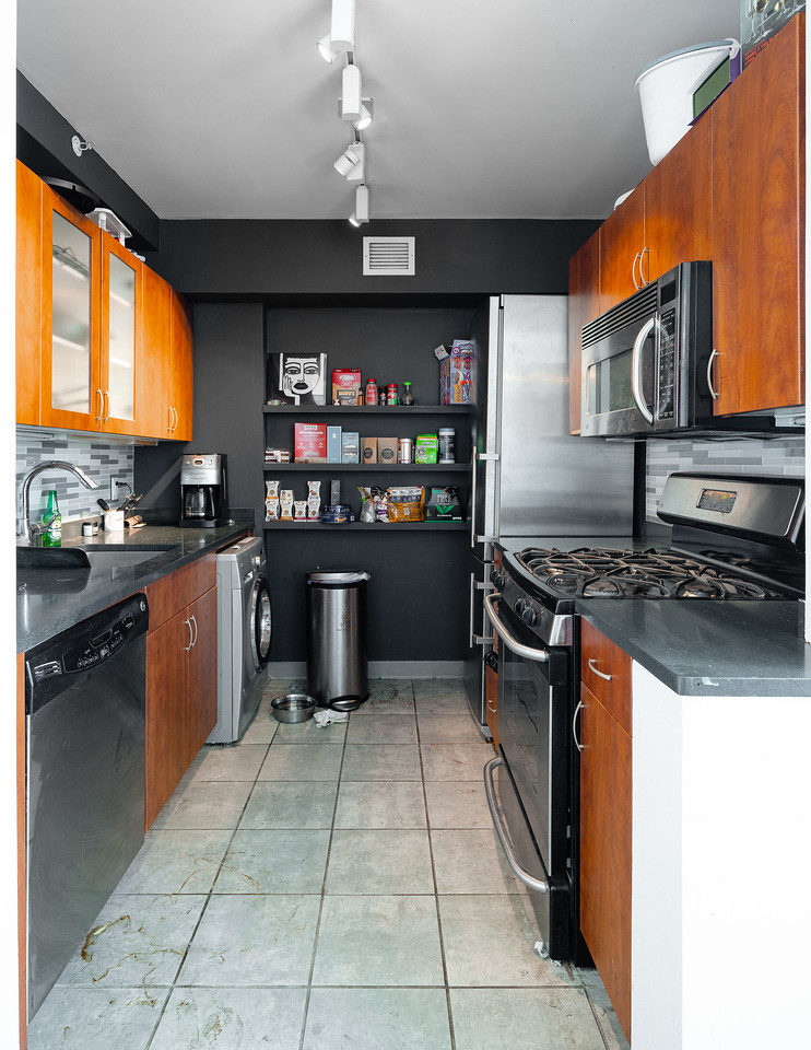 Kitchen before renovation showing outdated dark and narrow space