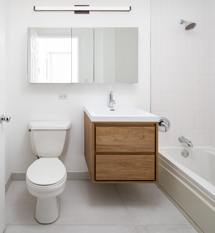 Bathroom after renovation with wooden vanity and matte black fixtures
