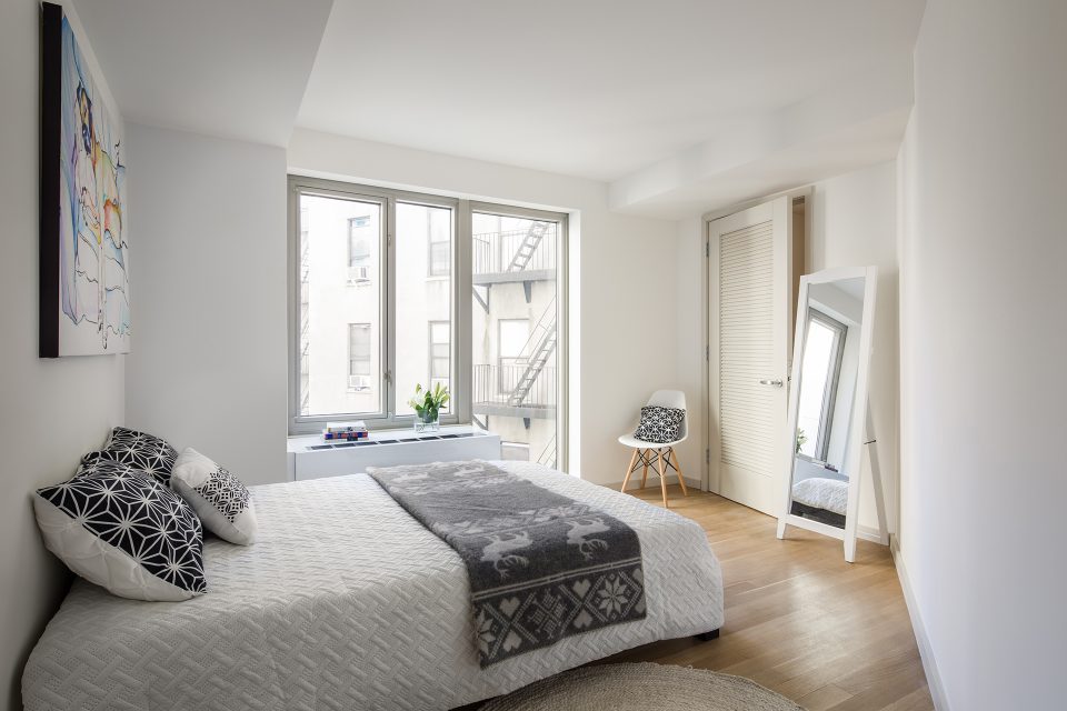 Upper West Side condo bathroom with floor-to-ceiling white ceramic tiles