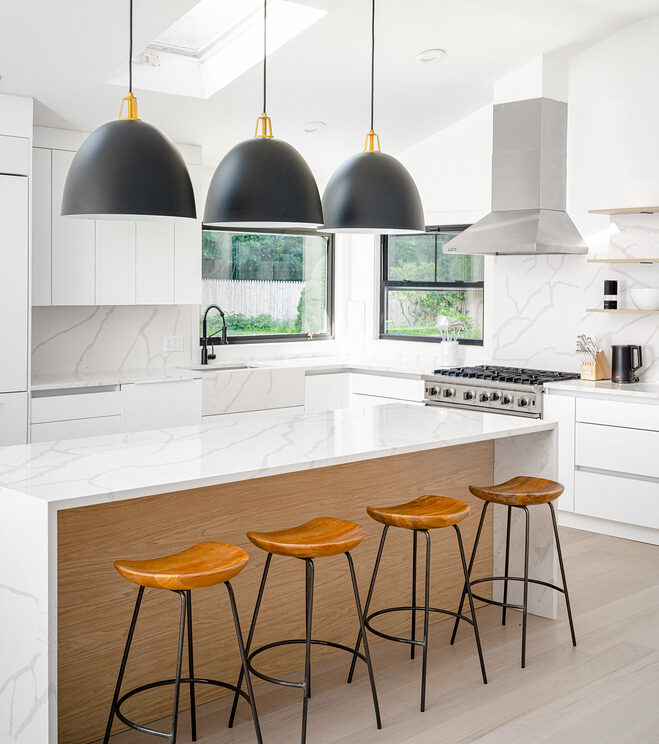 Kitchen island with white marble waterfall counter and recessed LED lights