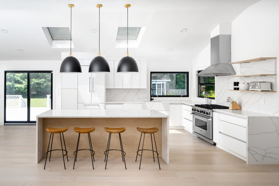 Kitchen island with white marble waterfall counter and recessed LED lights